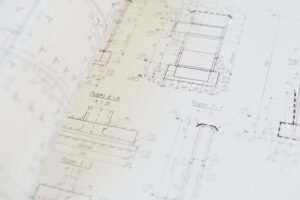 electrical certification documents on desk with blueprint and meter